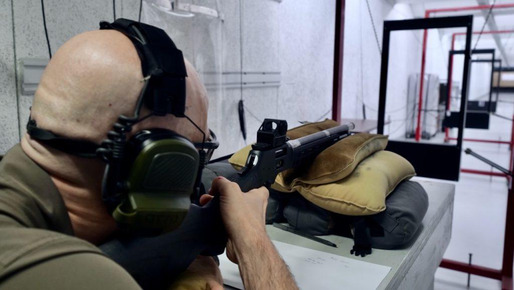 Author shooting a Henry SPD Hush .357 Magnum at an indoor facility through Oehler Model 36 chronograph screens
